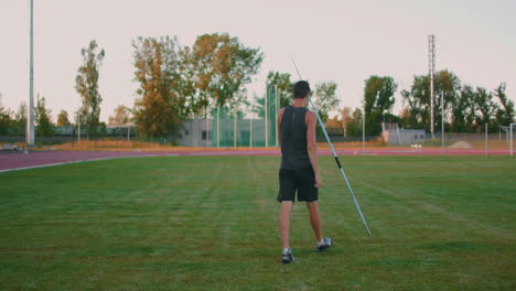 Slow-motion:-a-Male-athlete-at-the-stadium-concentrates-and-prepares-to-do-a-javelin-throw.-Attitude-and-serious-expression.-Goes-around-collecting-spears.-Training-of-a-javelin-thrower
